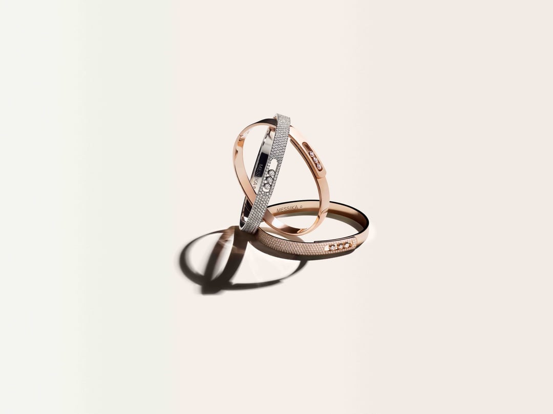 Drie elegante roségouden armbanden met diamantdetails en textuurwerk op neutrale achtergrond.